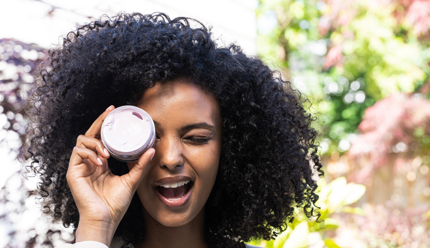 a woman holding Eminence Organics moisturizer
